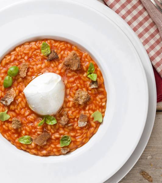 Risotto al pomodoro con cuore di bufala, croste di pane e basilico