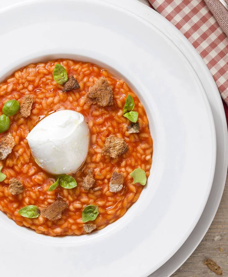 Risotto al pomodoro con cuore di bufala, croste di pane e basilico